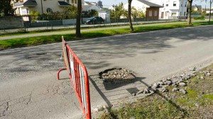 Agujero en la calzada de la VI Avenida en el barrio de Compostilla. Foto: Raúl C.